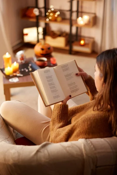 Jeune femme lecture livre à la maison sur halloween — Photo