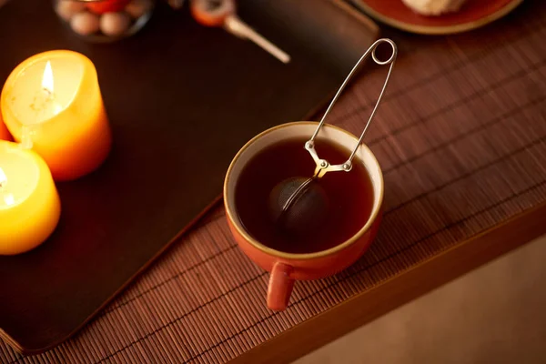 Mesh tea infuser ball in ceramic mug on halloween — Stock Photo, Image