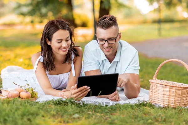 Couple heureux avec tablette pc au pique-nique dans le parc — Photo