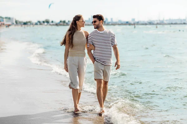 Щаслива пара гуляє вздовж літнього пляжу — стокове фото