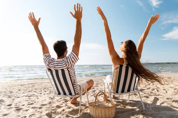 Gelukkig paar zitten in klapstoelen op het strand — Stockfoto