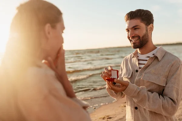 Man med ring gör förslag till kvinna på stranden — Stockfoto