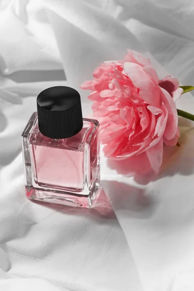 Bottle of perfume and flower on white sheet — Stock Photo, Image