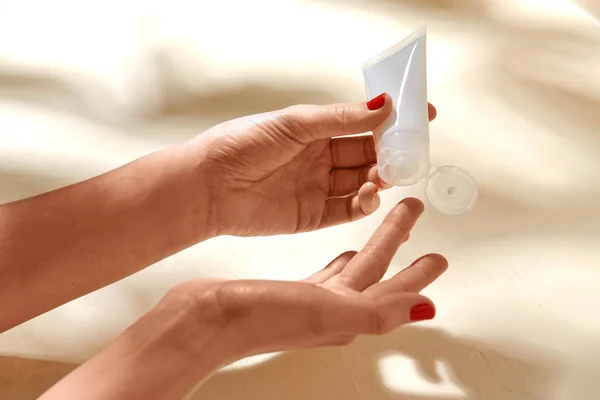 Female hands applying moisturizer to skin — Stock Photo, Image