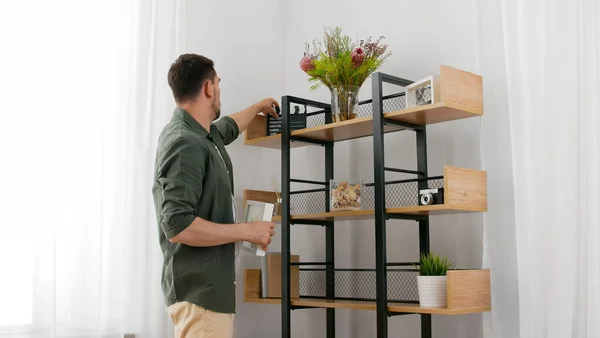 Hombre decorando el hogar y la organización de estantes — Foto de Stock