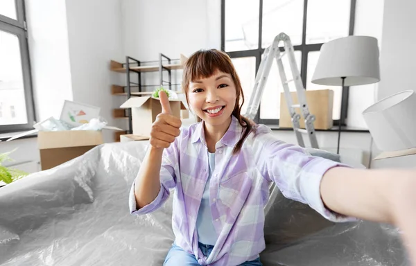 Sonriente asiático mujer tomando selfie en nuevo hogar —  Fotos de Stock