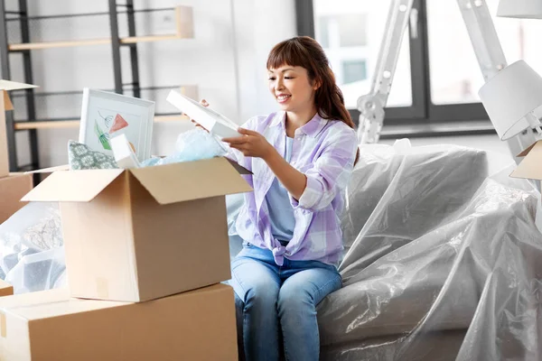 Mujer feliz desempacar cajas y mudarse a un nuevo hogar —  Fotos de Stock