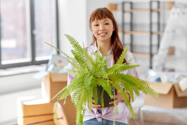 Mujer feliz con flor de helecho mudándose a un nuevo hogar —  Fotos de Stock