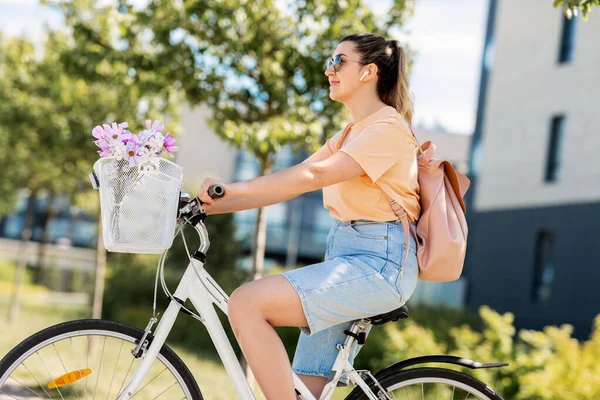 Femme heureuse avec écouteurs équitation vélo en ville — Photo