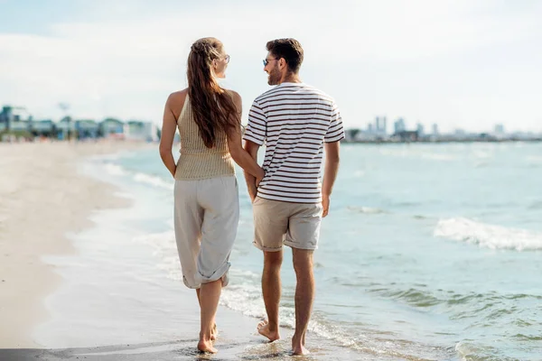 Coppia felice passeggiando lungo la spiaggia estiva — Foto Stock