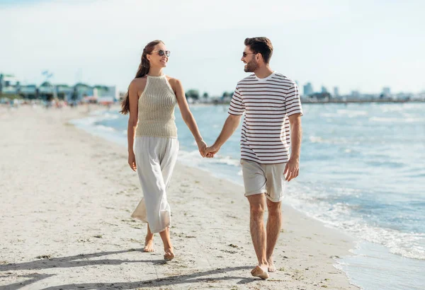 Coppia felice passeggiando lungo la spiaggia estiva — Foto Stock