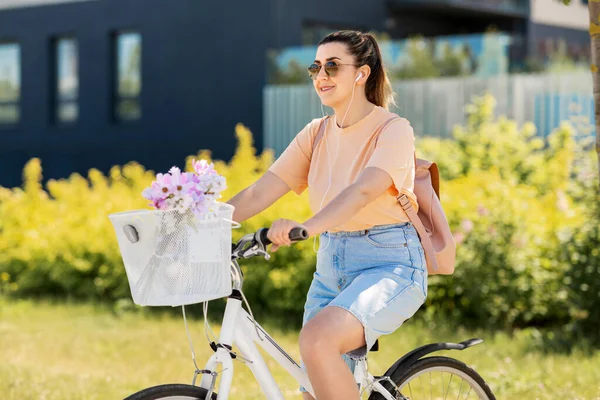 Mulher feliz com fones de ouvido andar de bicicleta na cidade — Fotografia de Stock