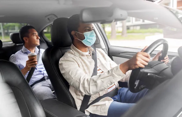 Male driver in mask driving car with passenger — Stock Photo, Image