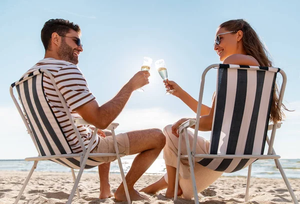 Lyckliga par dricker champagne på sommarstranden — Stockfoto