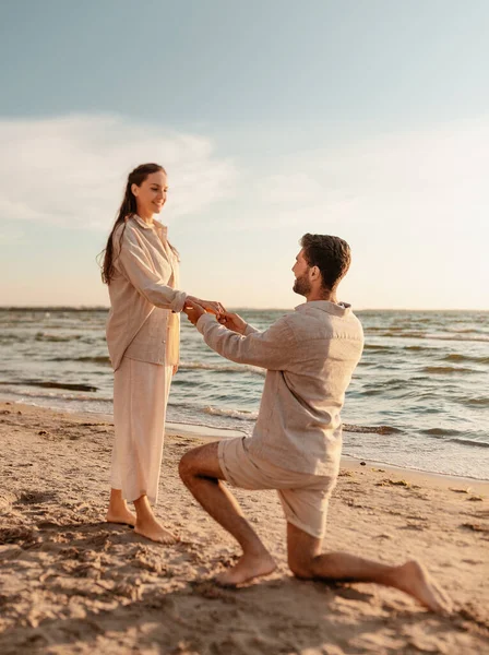 Uomo con anello che fa proposta alla donna sulla spiaggia — Foto Stock