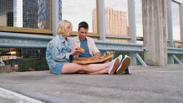 Šťastný pár jíst pizzu na ulici města — Stock video
