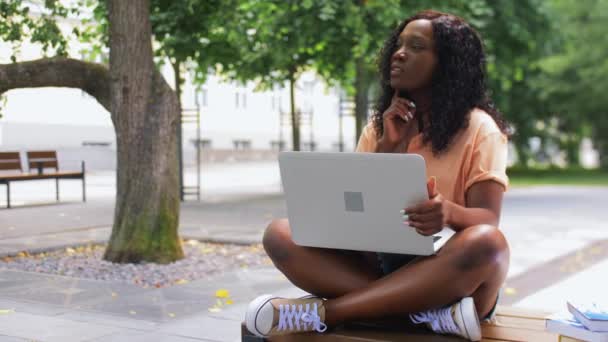 Menina estudante africano com laptop e livros na cidade — Vídeo de Stock