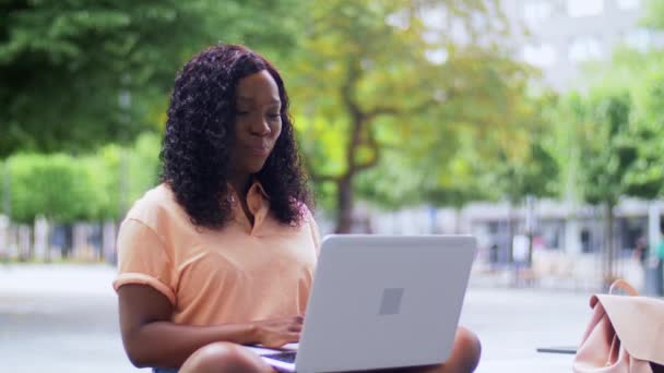 Afrikaans student meisje met laptop en boeken in de stad — Stockvideo