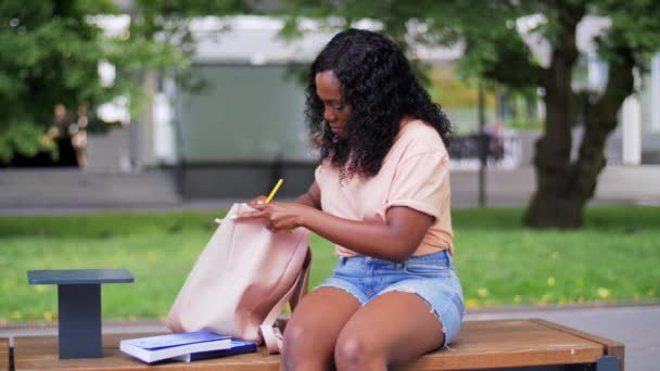 Afrykański student dziewczyna pakowanie książek do plecaka — Wideo stockowe