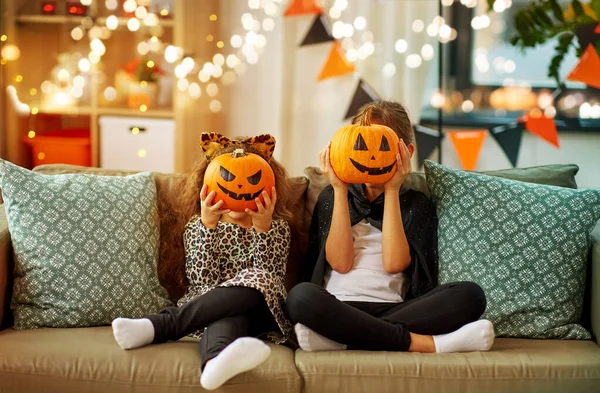 Flickor i halloween kostymer med pumpor hemma — Stockfoto