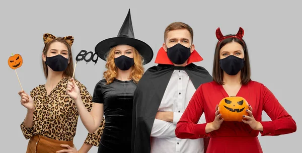 Przyjaciele w halloween kostiumy i czarne maski — Zdjęcie stockowe