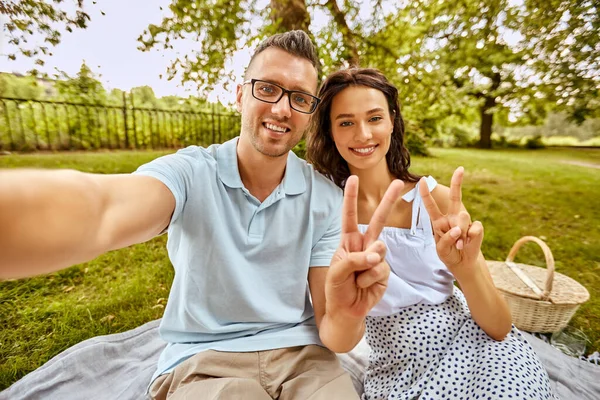 Feliz pareja tomando selfie en el picnic en el parque — Foto de Stock