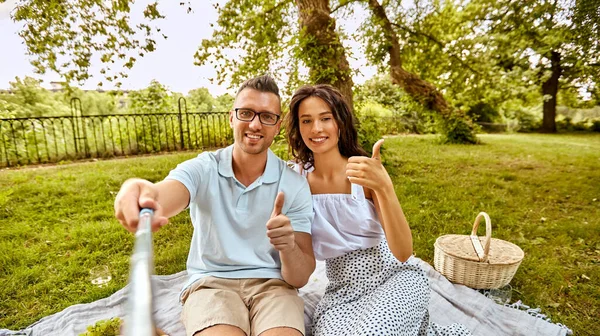 Szczęśliwy para biorąc selfie na piknik w parku — Zdjęcie stockowe