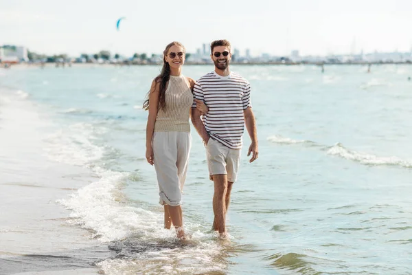 Coppia felice passeggiando lungo la spiaggia estiva — Foto Stock