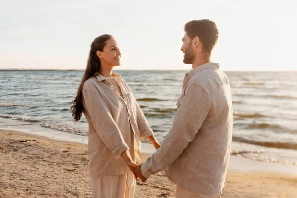 Gelukkig paar hand in hand op de zomer strand — Stockfoto