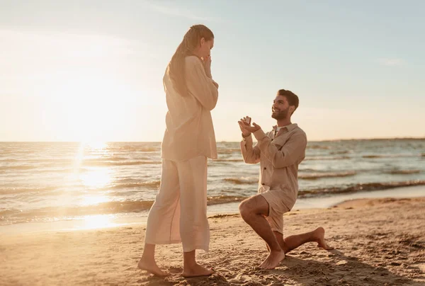 Man med ring gör förslag till kvinna på stranden — Stockfoto