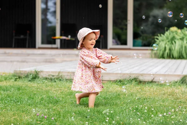 Heureux bébé fille jouer avec savon bulles à l'extérieur — Photo