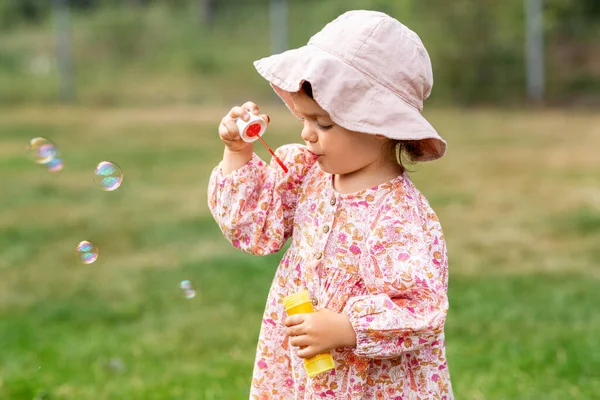 Gelukkig baby meisje blazen zeepbellen in de zomer — Stockfoto