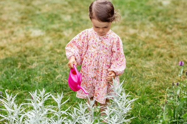 Heureux bébé fille avec arrosoir dans le jardin d'été — Photo