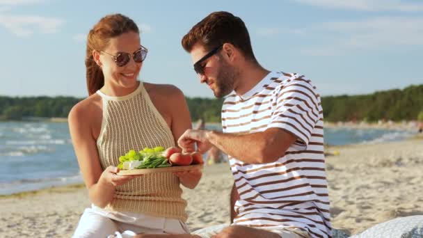 Felice coppia con cibo avendo pic-nic sulla spiaggia — Video Stock