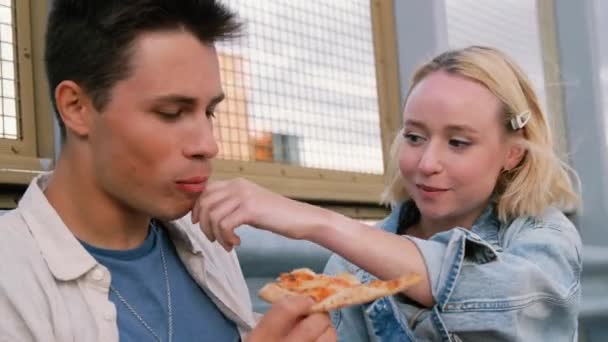 Ευτυχισμένο ζευγάρι τρώει πίτσα στο δρόμο της πόλης — Αρχείο Βίντεο
