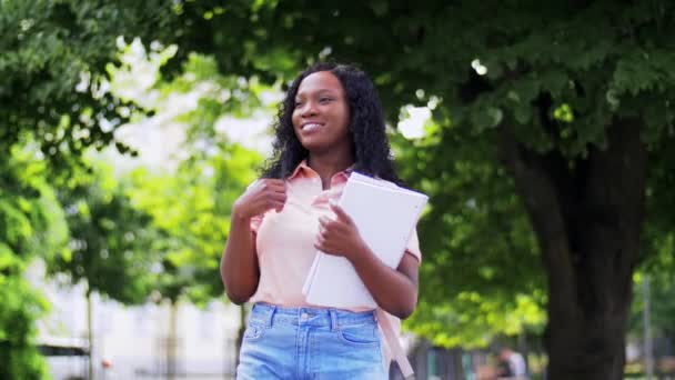 Şehirde not defterleri olan Afrikalı öğrenci kız. — Stok video