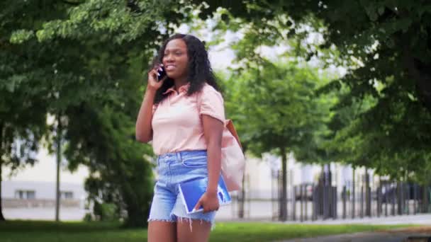 Menina estudante africana chamando no smartphone na cidade — Vídeo de Stock