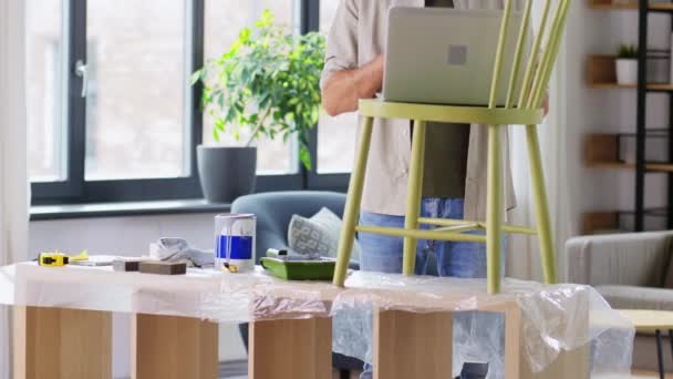 Mann mit Laptop bereitet alten Stuhl für Renovierung vor — Stockvideo