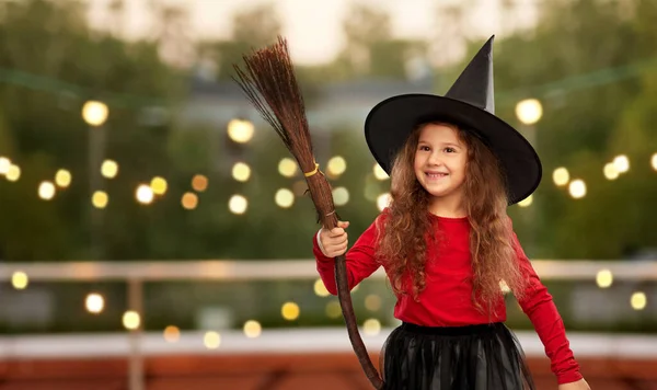 Girl in black witch hat with broom on halloween — Stock Photo, Image