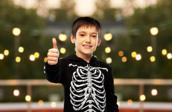 Jongen in halloween skelet kostuum toont duimen omhoog — Stockfoto