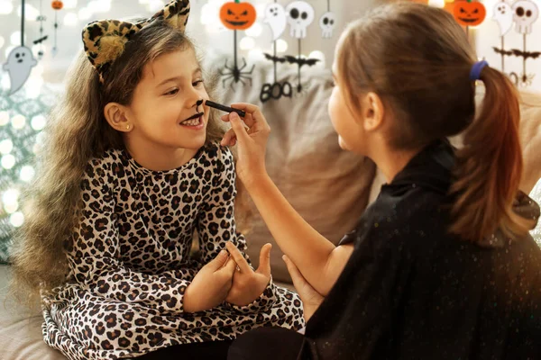 Girls doing face painting on halloween at home — Stock Photo, Image