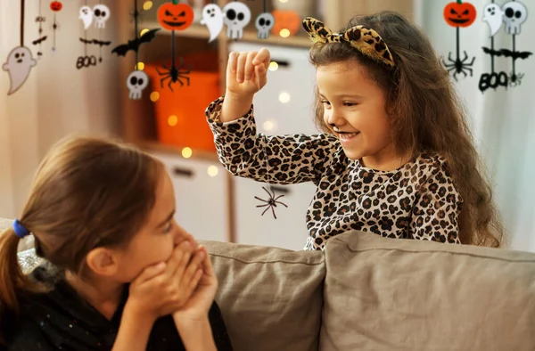 Meninas em trajes de Halloween jogando com aranha — Fotografia de Stock