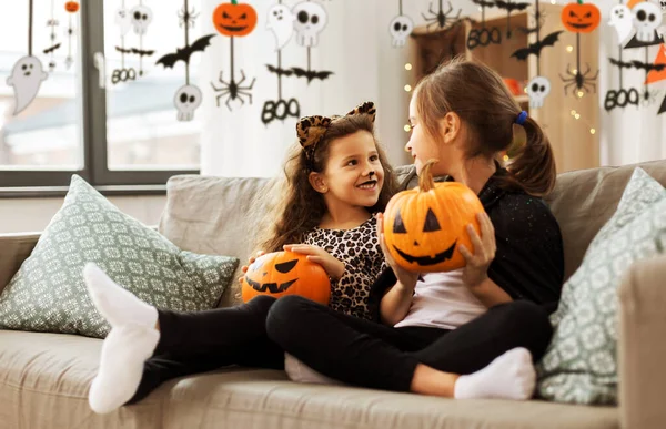 Flickor i halloween kostymer med pumpor hemma — Stockfoto