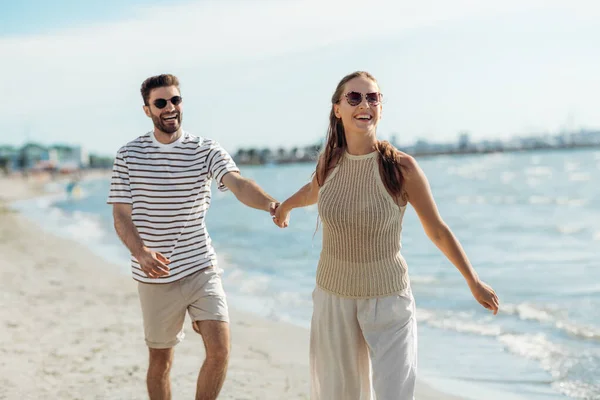 Coppia felice passeggiando lungo la spiaggia estiva — Foto Stock