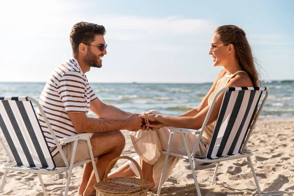 Щаслива пара сидить у розкладних стільцях на пляжі — стокове фото