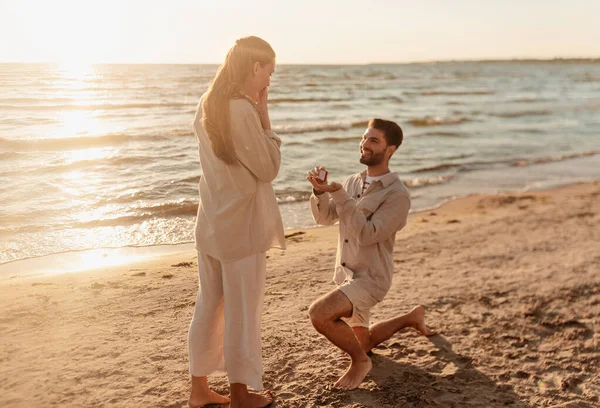 Muž s prstenem dělat nabídku k sňatku s ženou na pláži — Stock fotografie