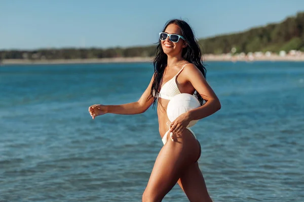 Frau im Bikini posiert mit Volleyball am Strand — Stockfoto