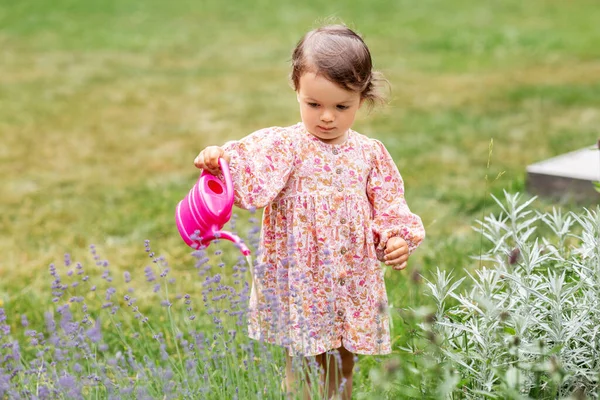 Heureux bébé fille avec arrosoir dans le jardin d'été — Photo