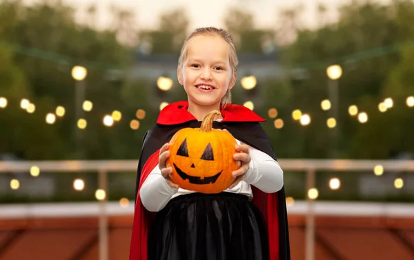 Girl in halloween costume of dracula with pumpkin — Stock Photo, Image