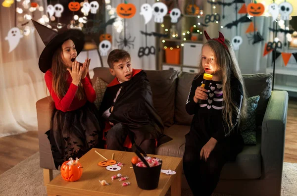 Ungar i halloween kostymer leker hemma — Stockfoto